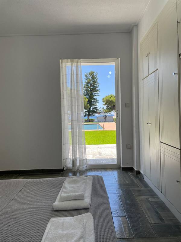 Bedroom with a balcony door opening to the pool and sea view